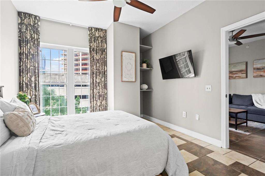 195 14th Street Northeast, Unit 604 Atlanta, GA 30309 - Photo 15 of 25 a bedroom with a large bed and a flat tv screen