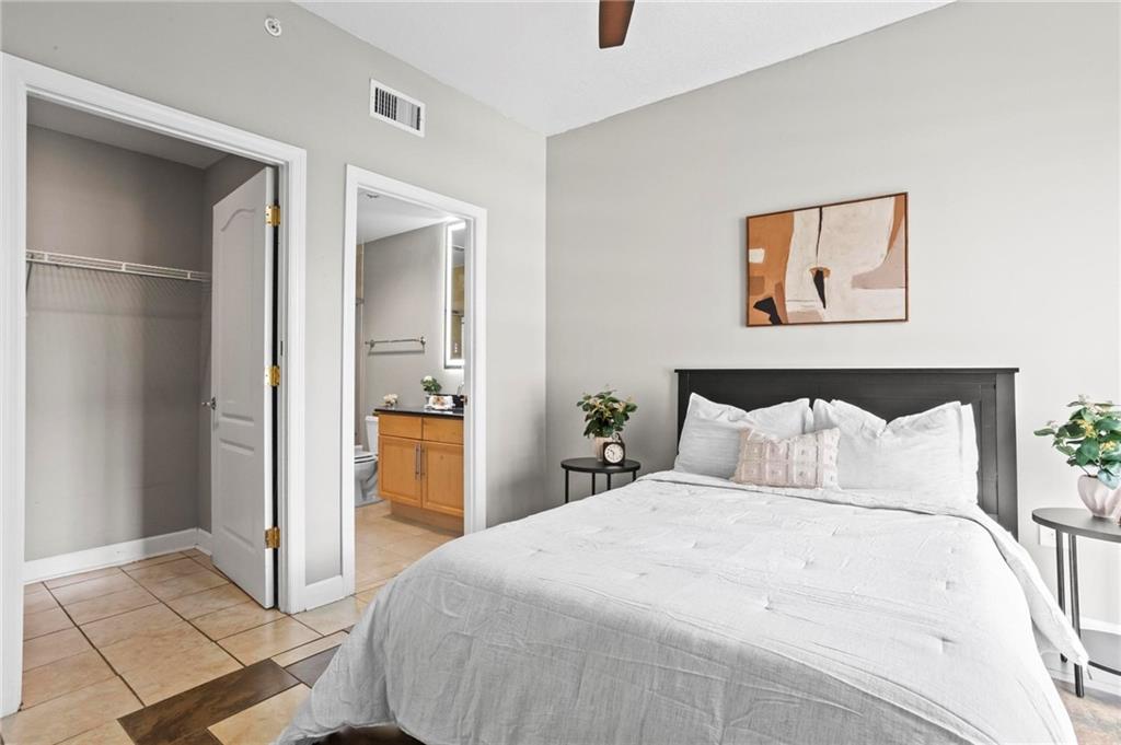 195 14th Street Northeast, Unit 604 Atlanta, GA 30309 - Photo 16 of 25 a bedroom with a bed and a painting on the wall