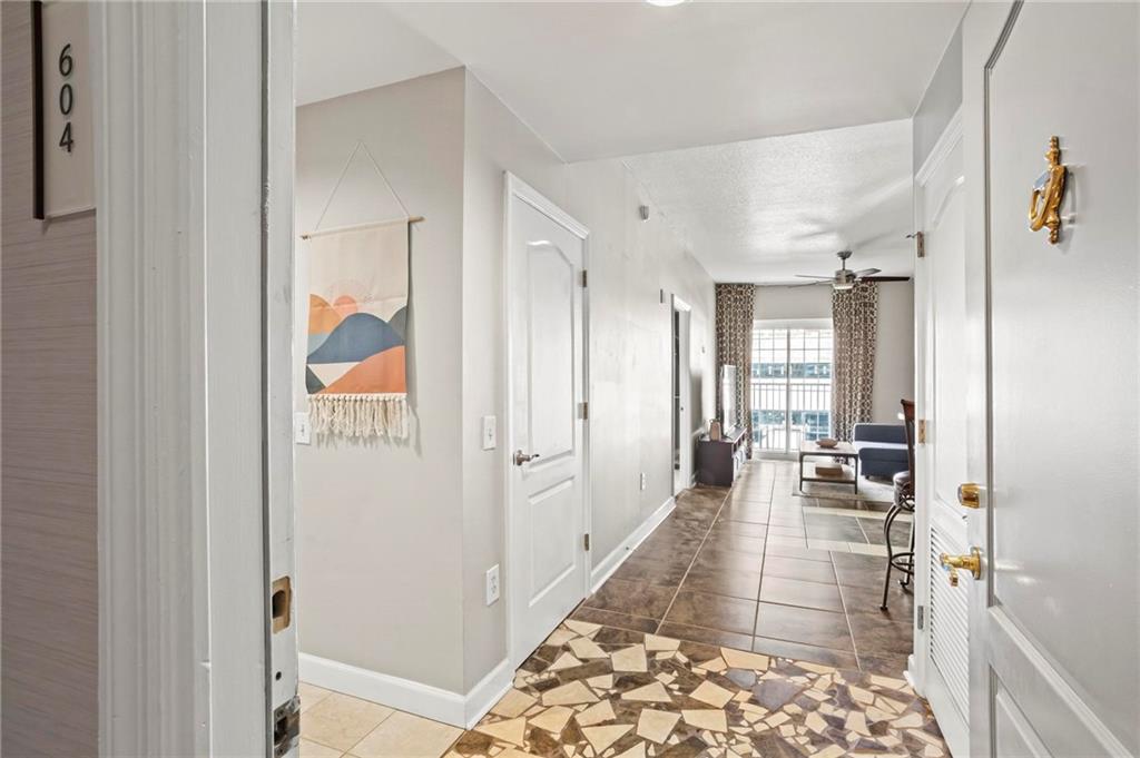 195 14th Street Northeast, Unit 604 Atlanta, GA 30309 - Photo 3 of 25 a hallway with white cabinets and chandelier