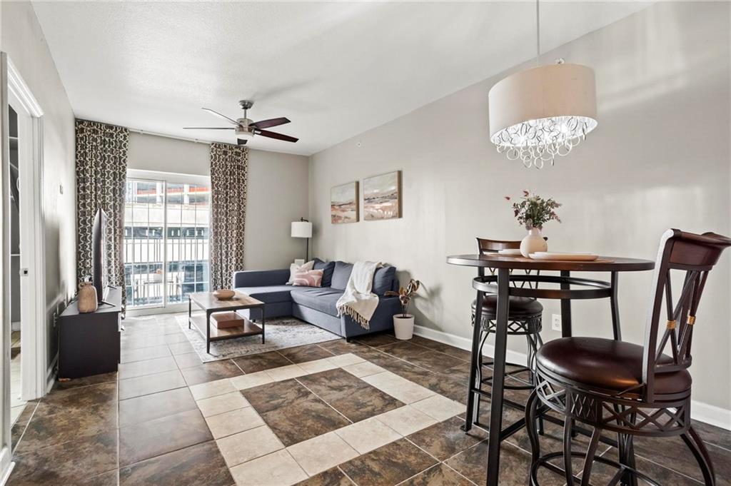 195 14th Street Northeast, Unit 604 Atlanta, GA 30309 - Photo 4 of 25 a living room with furniture two lamps and a chandelier