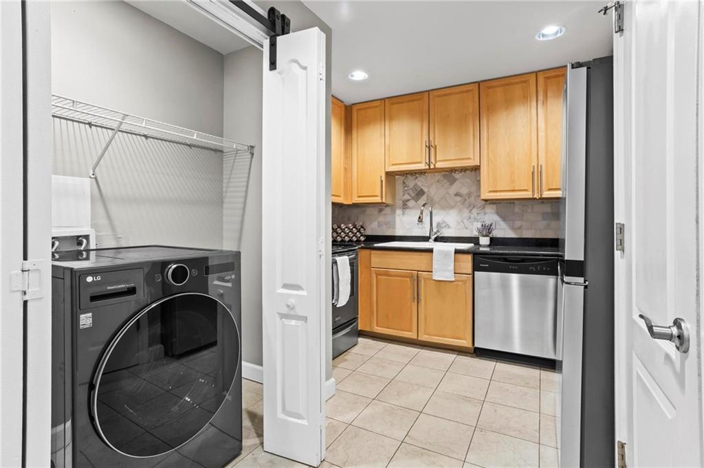 195 14th Street Northeast, Unit 604 Atlanta, GA 30309 - Photo 10 of 25 a kitchen with a washer and dryer