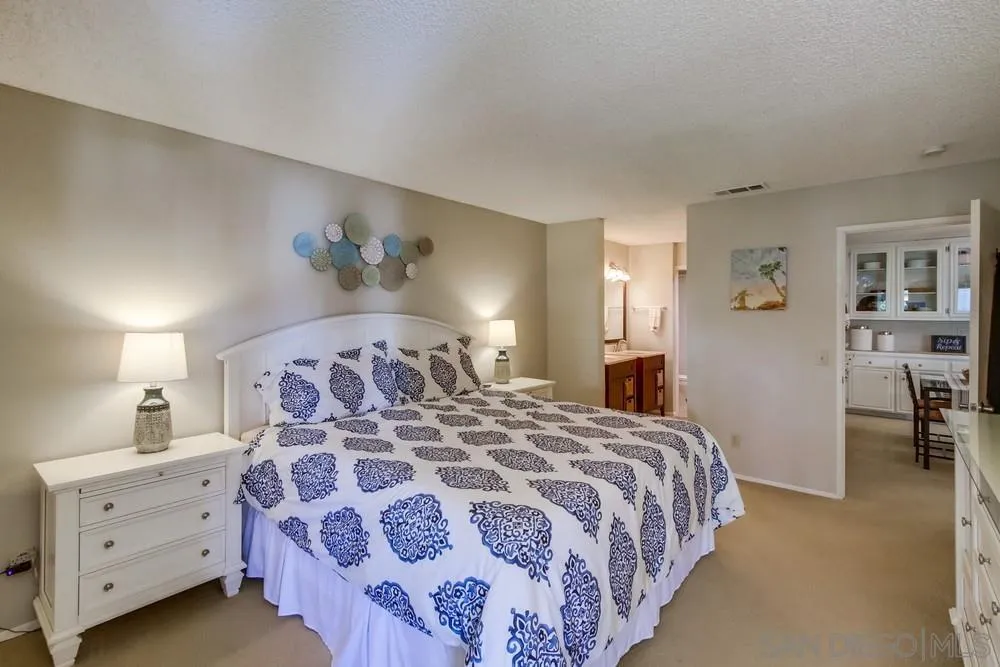 17617 Pomerado Road, Unit 215 San Diego, CA 92128 - Photo 12 of 50 a bedroom with a large bed and a chandelier