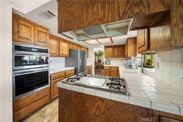a kitchen with stainless steel appliances a stove a sink and cabinets