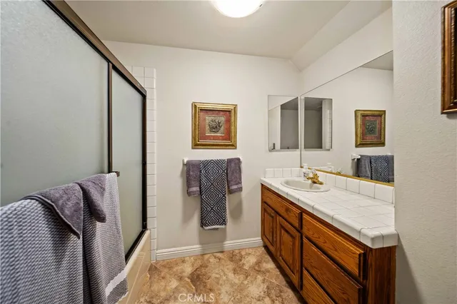 a bathroom with a granite countertop sink and a mirror