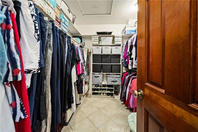 a view of walk in closet with clothes