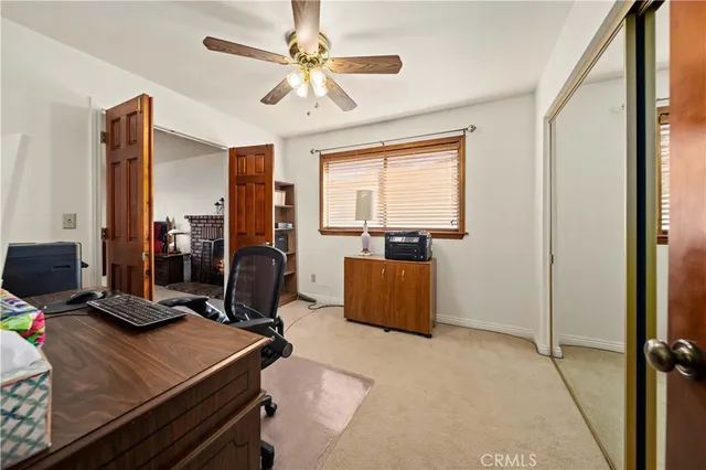 a view of a workspace with furniture and a window