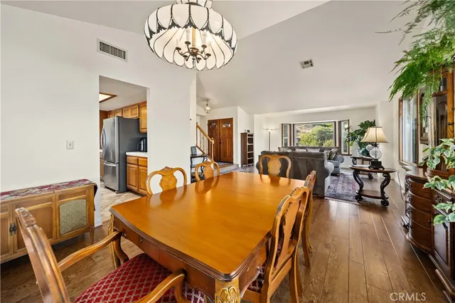 a dining room with furniture a chandelier and wooden floor
