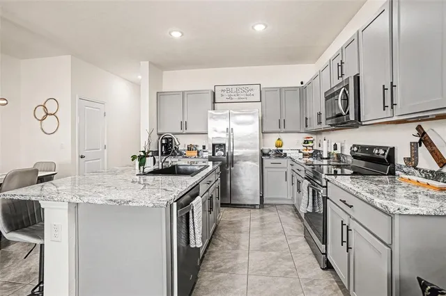 a kitchen with stainless steel appliances granite countertop a sink stove and refrigerator
