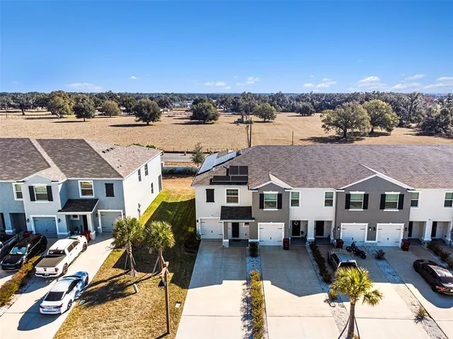 an aerial view of multiple houses with yard