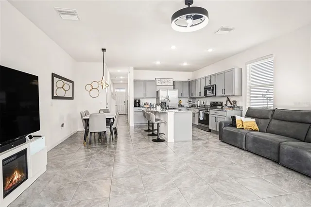 a living room with furniture a flat screen tv and kitchen view