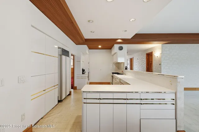 a kitchen with stainless steel appliances granite countertop a stove a sink and white cabinets