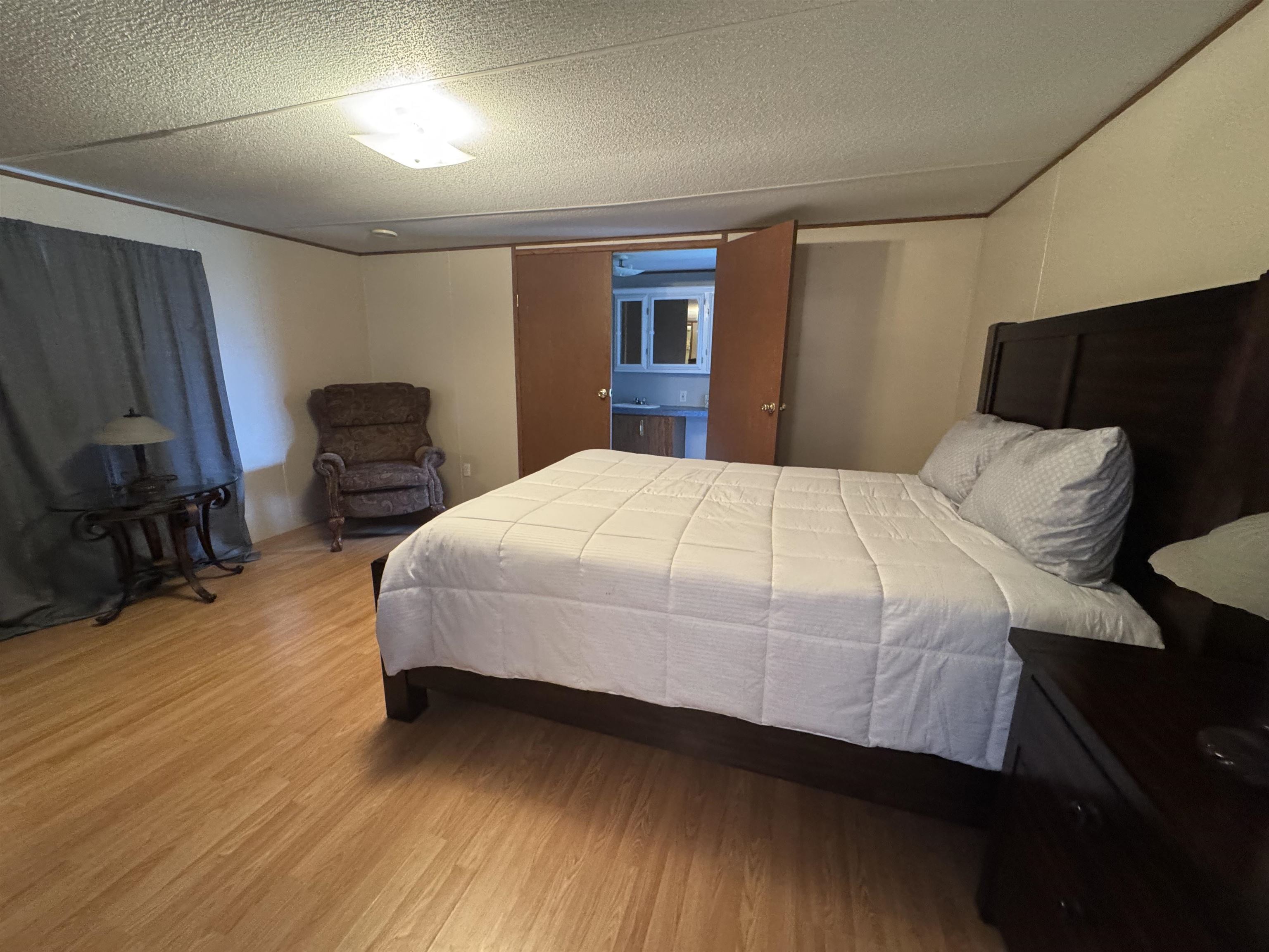 2511 Watkins Road Michie, TN 38357 - Photo 16 of 40 Spacious bedroom featuring wood-finish flooring, light-toned walls, and a ceiling-mounted light fixture