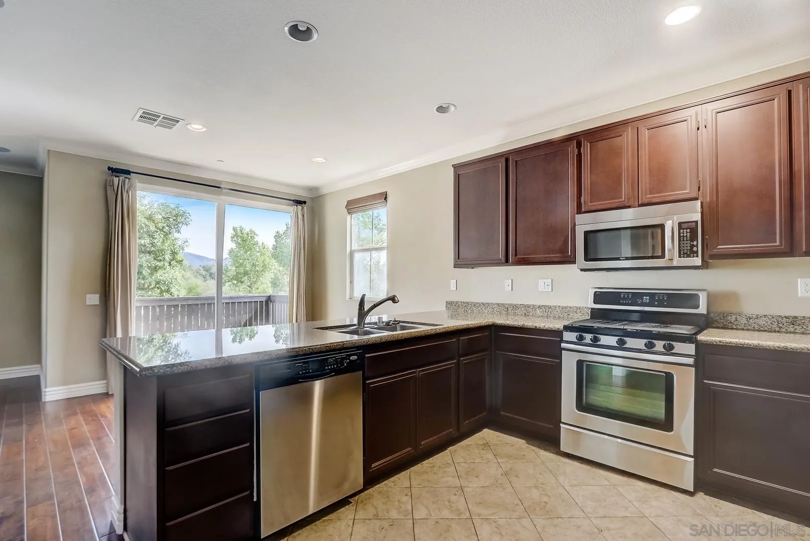10185 Leavesly Trail Santee, CA 92071 - Photo 17 of 27 a kitchen with a sink stove and microwave