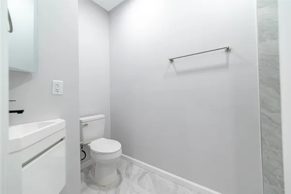 a white toilet sitting next to a bathroom sink