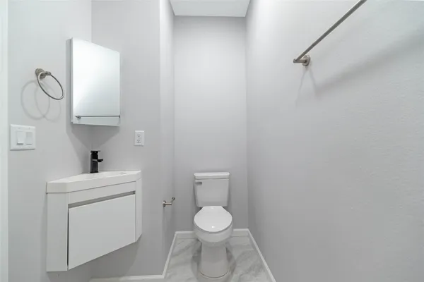 a bathroom with a toilet sink vanity and mirror