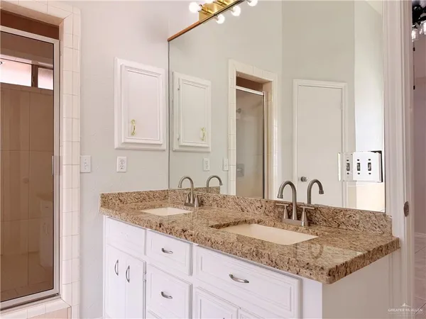 a bathroom with a granite countertop sink and a mirror