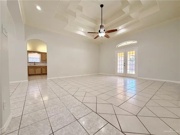 an empty room with windows and ceiling fan