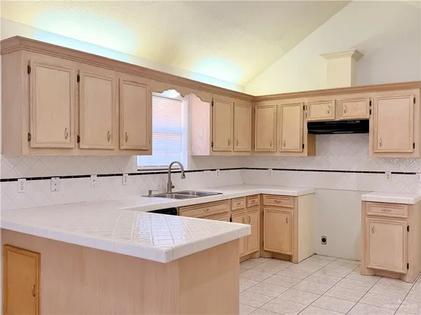 a kitchen with white cabinets and sink