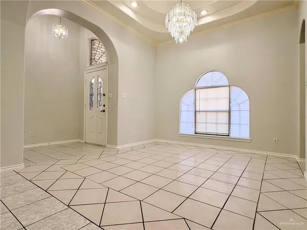 an empty room with windows and chandelier