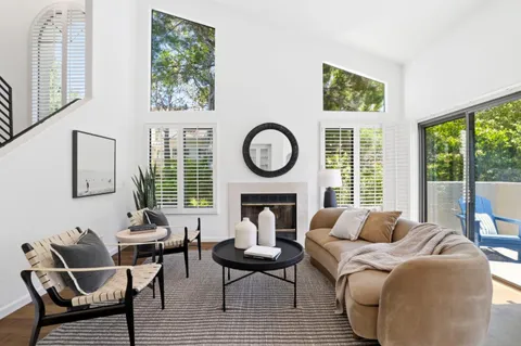 a living room with fireplace furniture and a large window