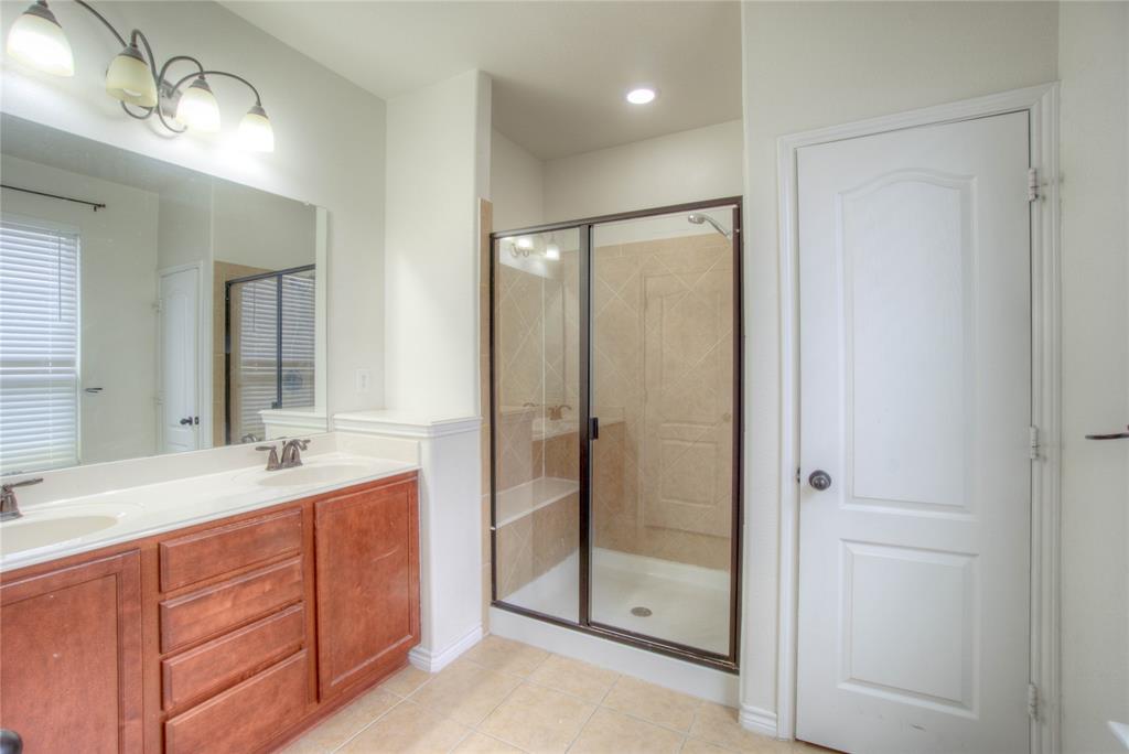 5633 Ridge Lake Drive Fort Worth, TX 76244 - Photo 14 of 23 Full bathroom with double vanity, a shower stall, and light tile patterned floors