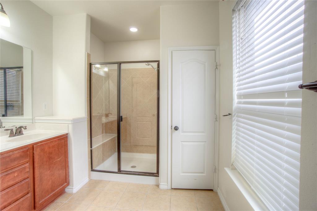 5633 Ridge Lake Drive Fort Worth, TX 76244 - Photo 15 of 23 Full bathroom featuring a shower stall, vanity, and light tile patterned floors
