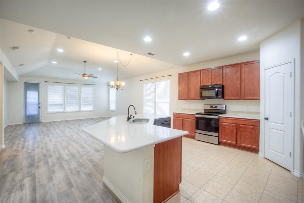 5633 Ridge Lake Drive Fort Worth, TX 76244 - Photo 4 of 23 Kitchen with black appliances, ceiling fan, light countertops, wood finish cabinets, and suspended lighting