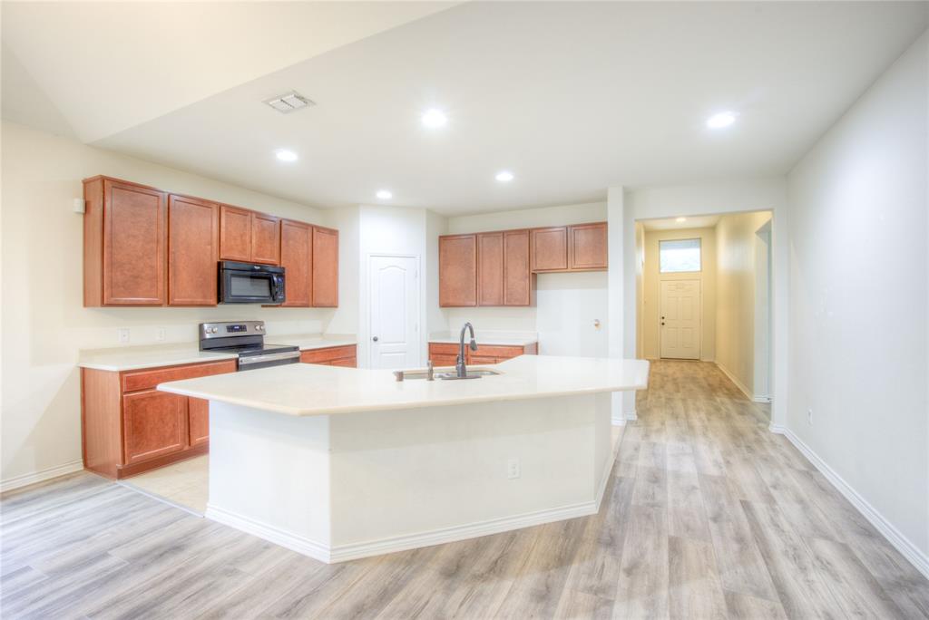 5633 Ridge Lake Drive Fort Worth, TX 76244 - Photo 5 of 23 Kitchen featuring light countertops, stainless steel electric stove, recessed lighting, black microwave, and an island with sink