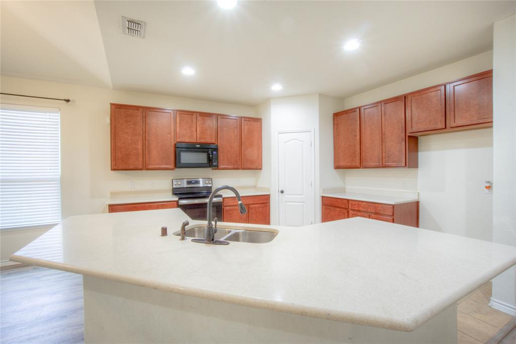 5633 Ridge Lake Drive Fort Worth, TX 76244 - Photo 6 of 23 Kitchen with electric range, recessed lighting, black microwave, a center island with sink, and wood finish cabinetry