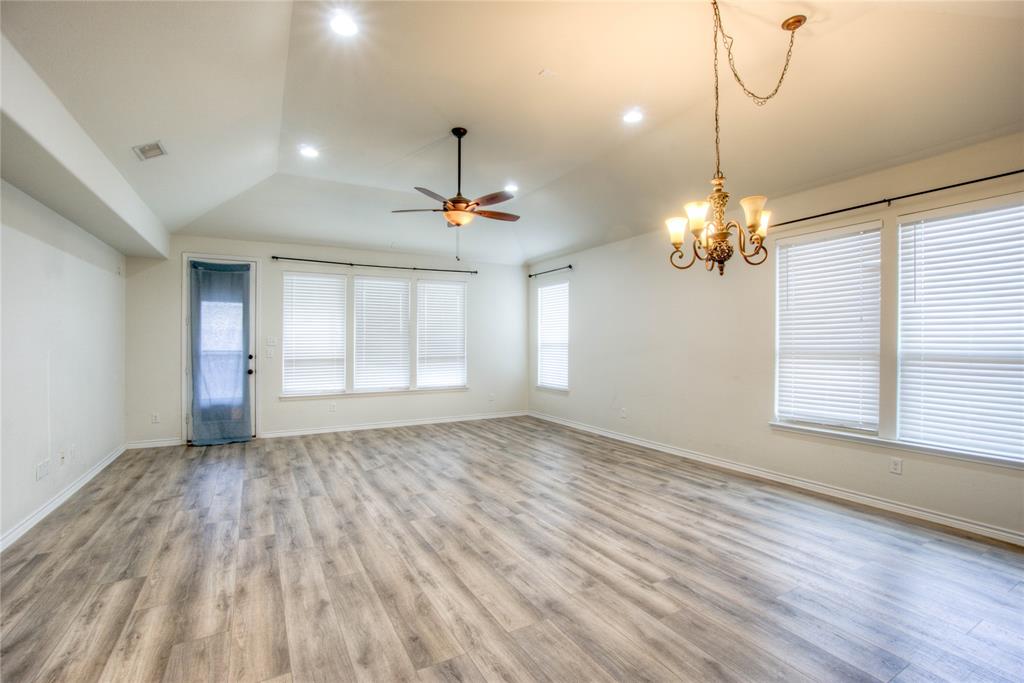 5633 Ridge Lake Drive Fort Worth, TX 76244 - Photo 8 of 23 Unfurnished room with a ceiling fan, suspended lighting, light wood-style floors, vaulted ceiling, and plenty of natural light