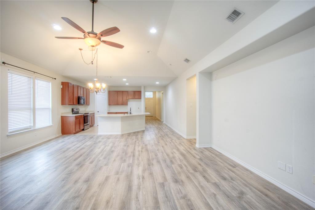 5633 Ridge Lake Drive Fort Worth, TX 76244 - Photo 9 of 23 Unfurnished living room featuring hanging lights, ceiling fan, light wood finished floors, and vaulted ceiling