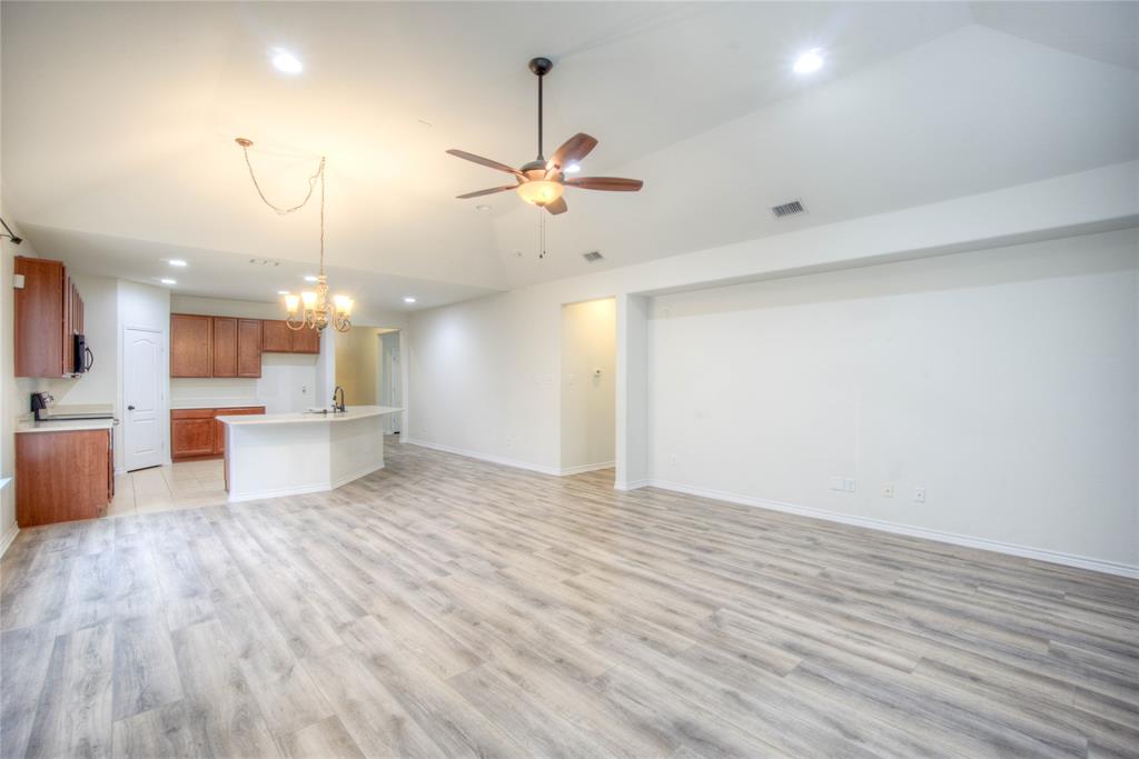 5633 Ridge Lake Drive Fort Worth, TX 76244 - Photo 23 of 23 Kitchen featuring open floor plan, suspended lighting, lofted ceiling, an island with sink, and light countertops