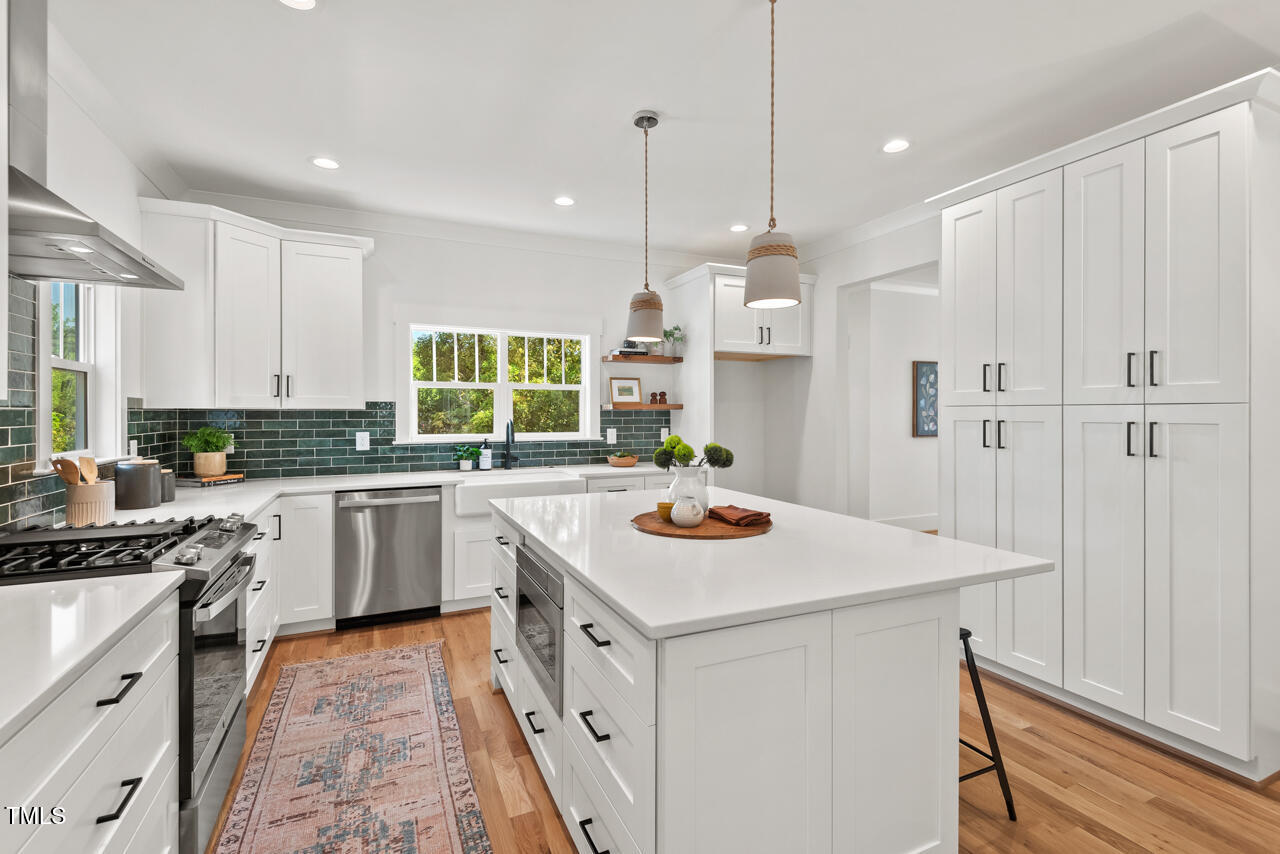 2019 James Street Durham, NC 27707 - Photo 13 of 46 a kitchen that has a sink a stove and a wooden floor