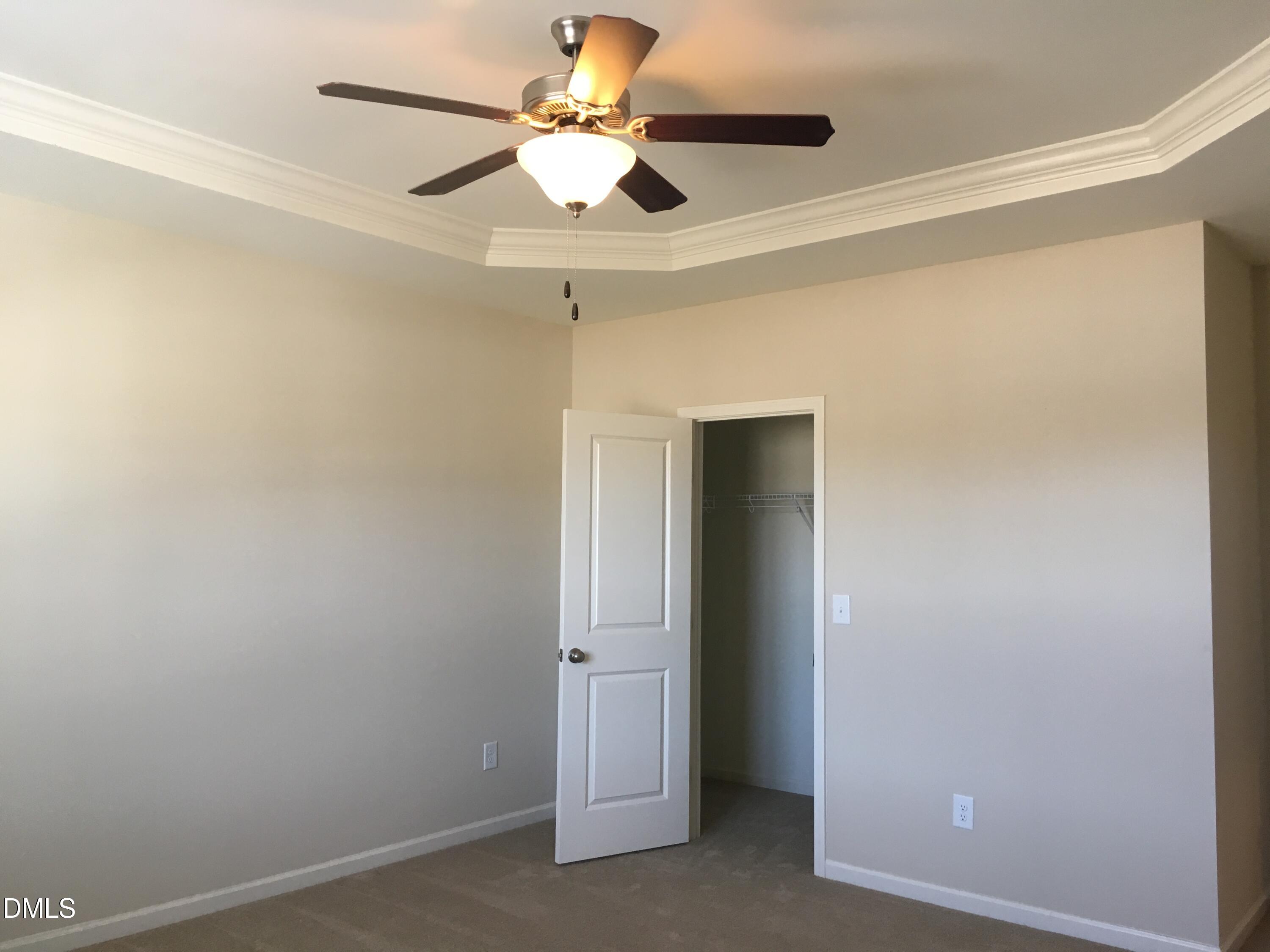 134 Zante Currant Road, Unit 134 Durham, NC 27703 - Photo 8 of 14 an empty room with a chandelier fan and a ceiling fan