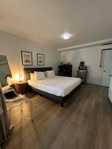 a bedroom with two beds and wooden floor