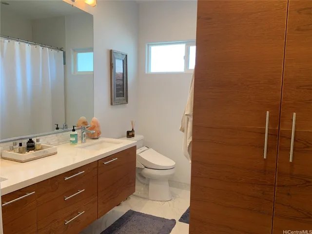 a bathroom with a granite countertop sink toilet and shower