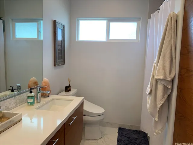 a bathroom with a sink a toilet and a mirror
