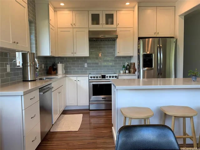 a kitchen with stainless steel appliances granite countertop a stove refrigerator and cabinets