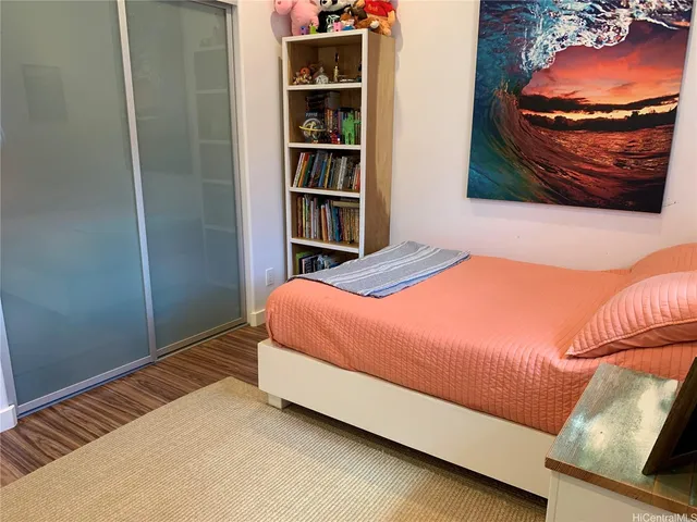 a bedroom with a bed and a painting on the wall