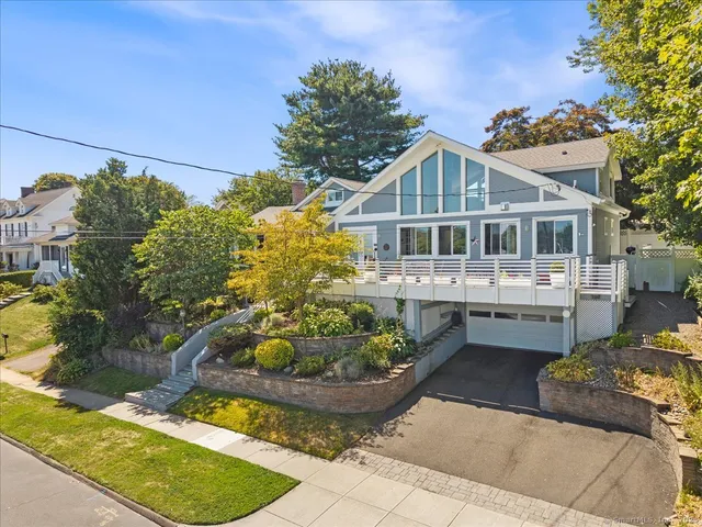 a front view of a house with a yard and potted plants