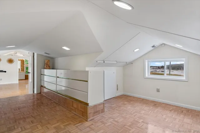 a view of hallway with a large window and wooden floor