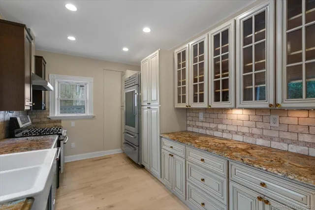 a kitchen with granite countertop a sink stove and refrigerator