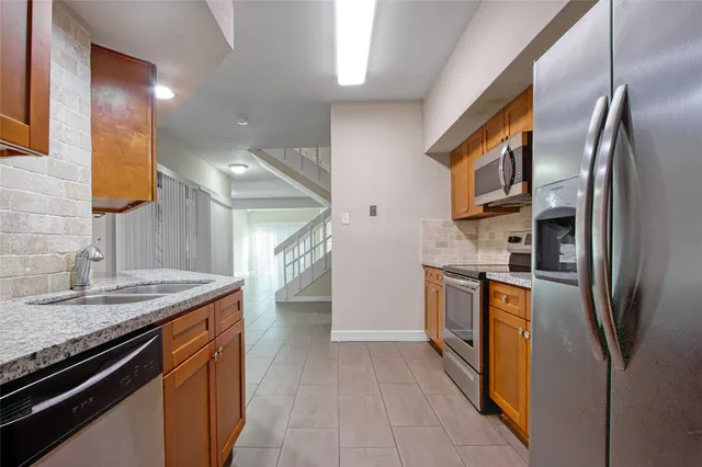 a kitchen with stainless steel appliances granite countertop a refrigerator and a stove