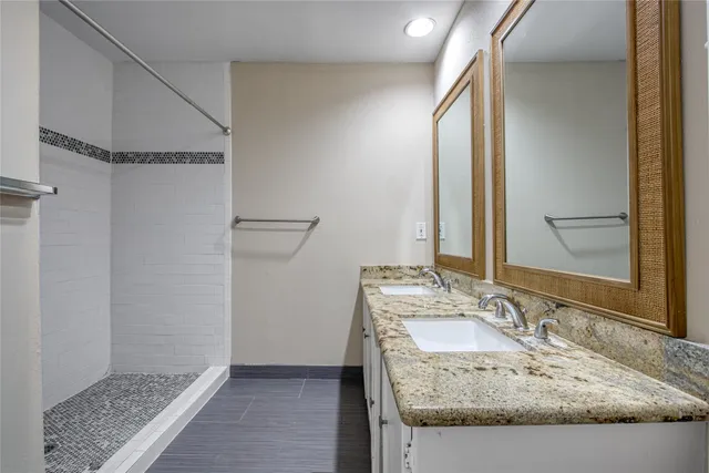 a bathroom with a granite countertop sink and a mirror