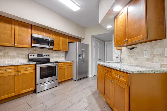 a kitchen with stainless steel appliances granite countertop a stove a sink and a microwave