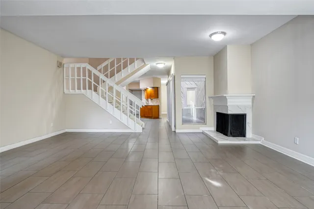 a view of a livingroom with wooden floor fireplace and staircase
