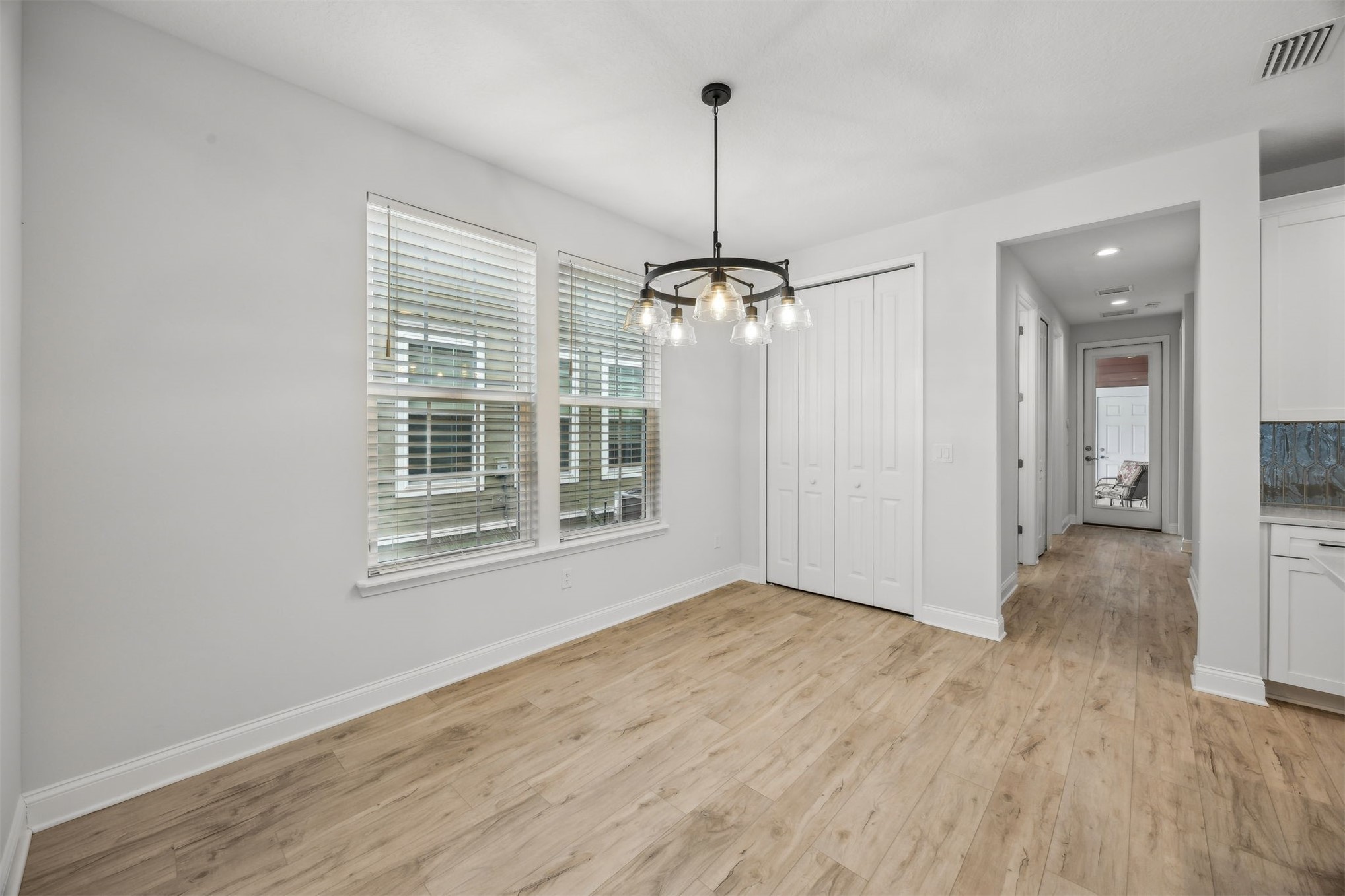 230 Wildlight Avenue Yulee, FL 32097 - Photo 7 of 73 a view of an empty room with wooden floor kitchen view and a window