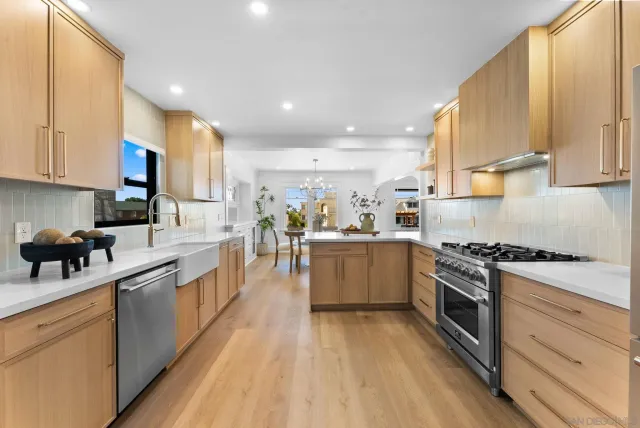 a kitchen with stainless steel appliances granite countertop a stove a sink and a refrigerator