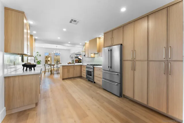 a kitchen with stainless steel appliances a refrigerator and a stove top oven