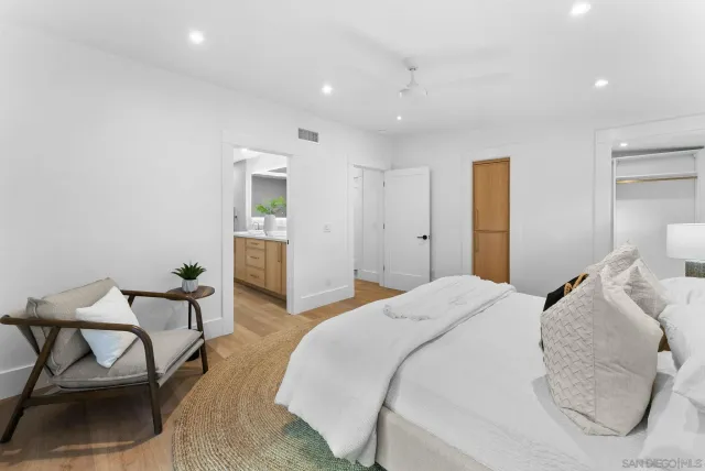 a spacious bedroom with a bed and chair